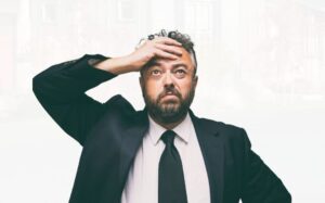 Worried NRI man holding head after not receiving property payment in India – Sandhu Law Offices